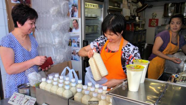 一名香港女子正在购买豆奶。很多亚洲人喝牛奶都会感到不舒服，因为亚洲人是乳糖分解酶续存性比例最低的人群之一。